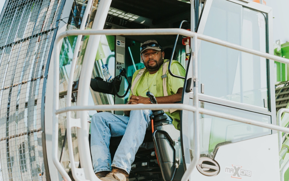 Heavy equipment operator inside recycling facility cab