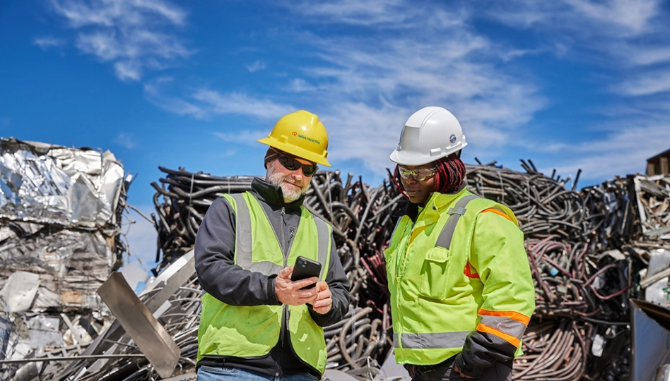 Radius Recycling employees reviewing operations at scrap yard