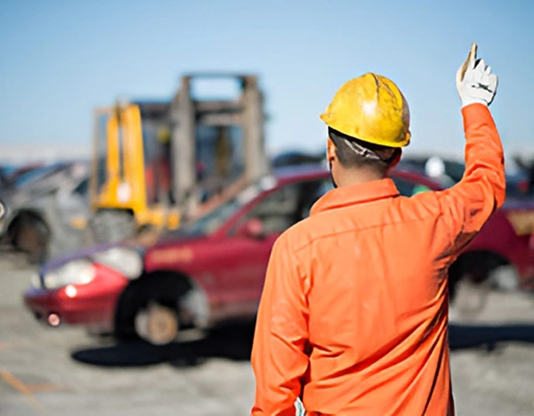 Worker directing vehicle dismantling and recycling operations