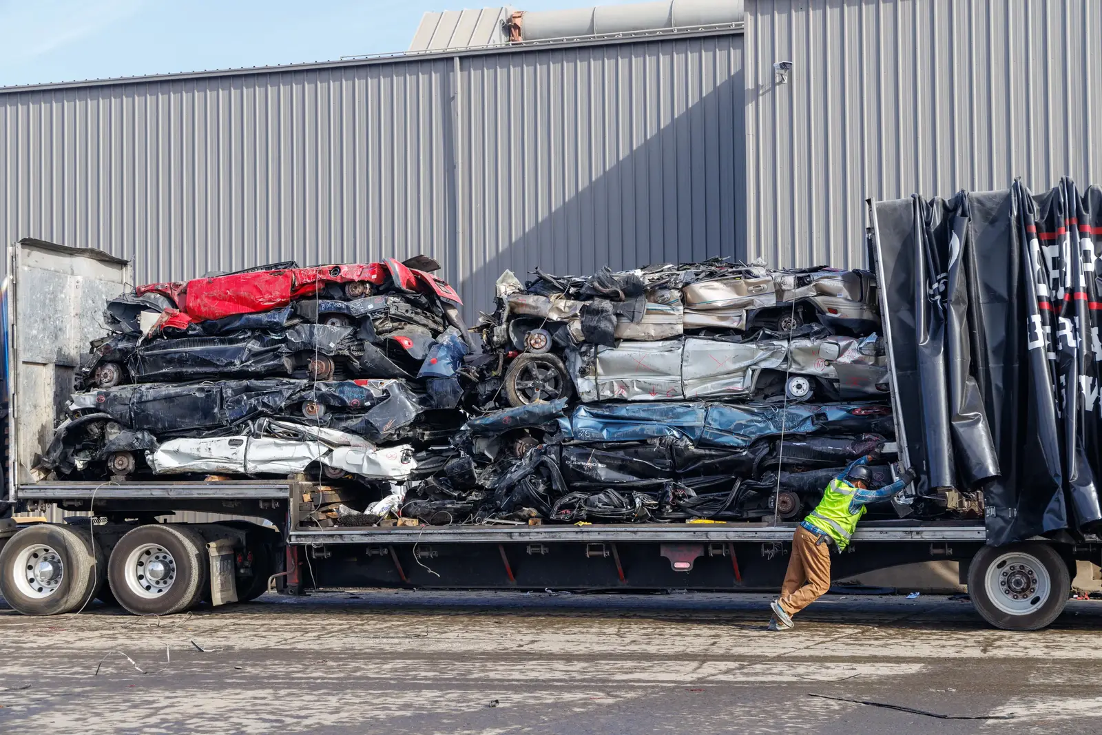 Crane lifting junk cars for responsible car recycling and metal processing