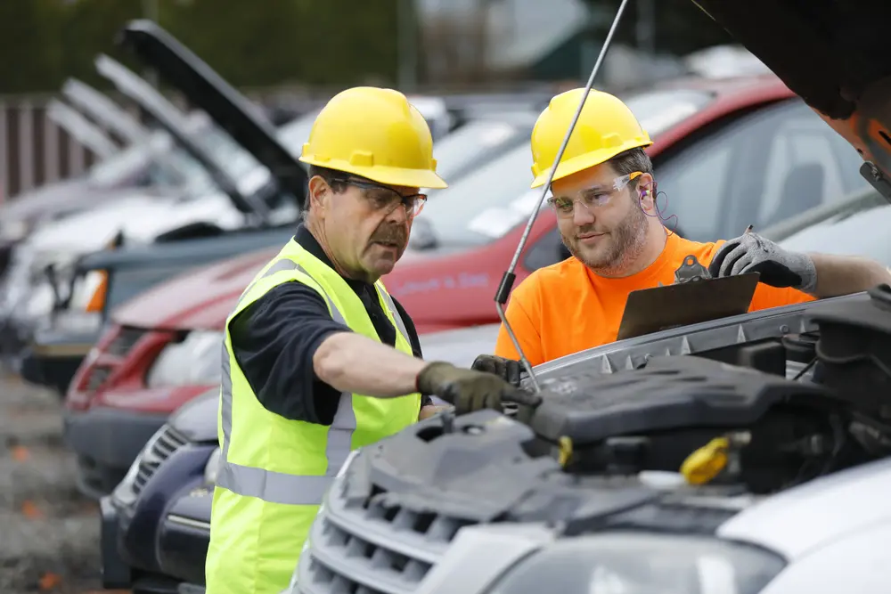 Radius Recycling team inspecting a vehicle to sell a car for parts and recycling