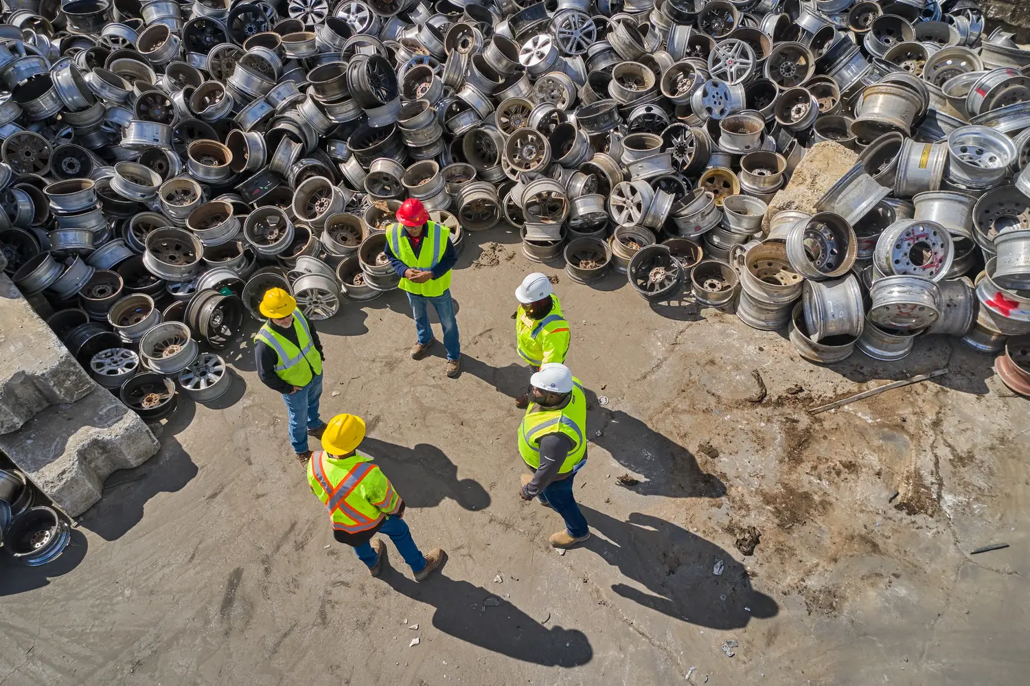 Scrap metal brokers reviewing material at a recycling yard